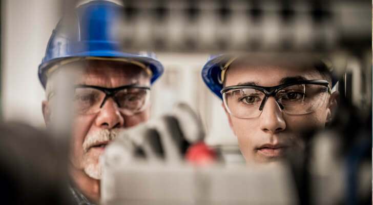 Two service men working on an electrical system