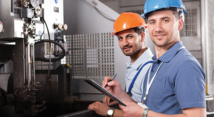 Two male safety team members holding a clipboard and evaluating an electrical system